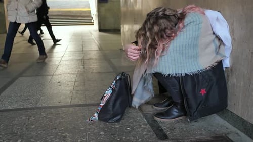Ein einsames trauriges Mädchen sitzt in einer Unterführung