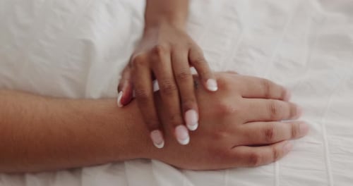 Woman Applying Lotion to a Man's Hand