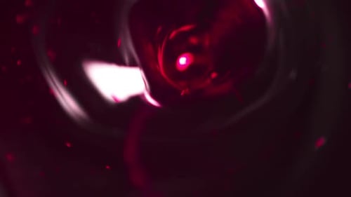 Abstract Funnel Quickly Rushing Into Deep in Cherry Liquid with Many Suspended Grains and Moving