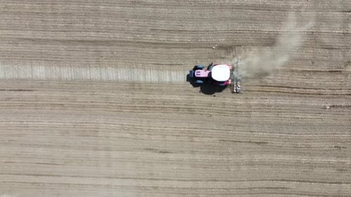 Tractor plowing the field - Red tractor plowing the field, 4k aerial shot with drone