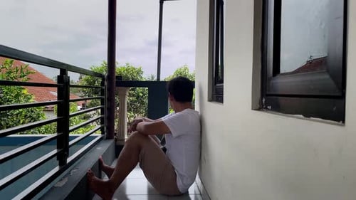 Young Adult Sitting on a Porch Wall