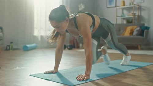 Beautiful Confident Strong Fitness Female in a Grey Athletic Outfit is Doing Mountain Climber Exerc