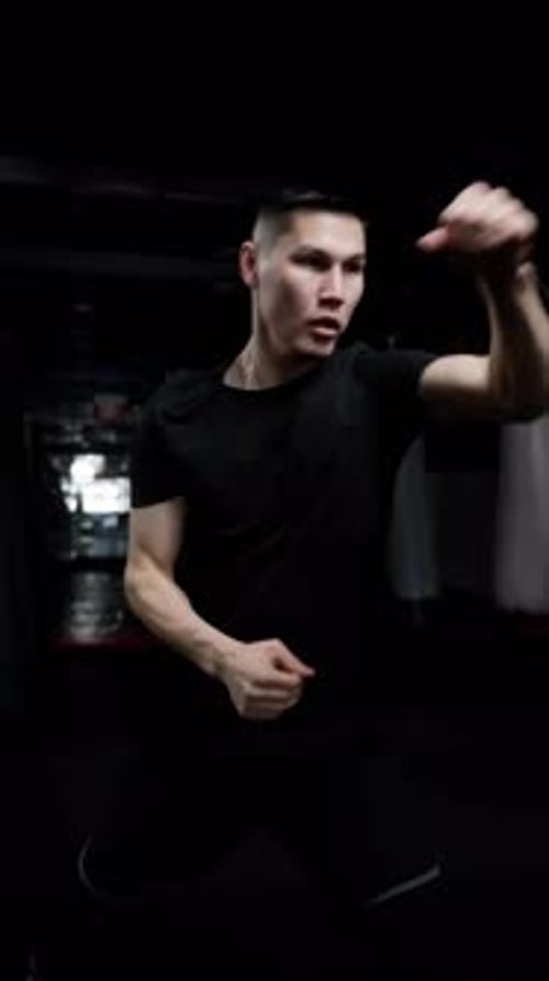 Man Practicing Boxing Shadow Fighting in Dark Gym