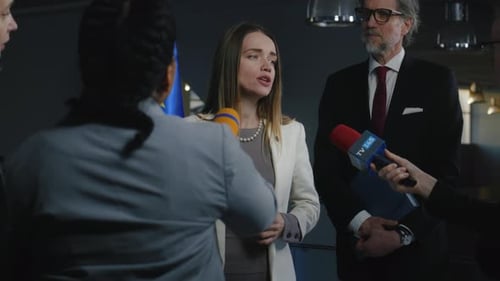 Woman Answers Questions at Press Conference with Reporters