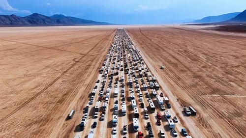 Multi-lane road crossing the desert is stuck with cars and campervans.