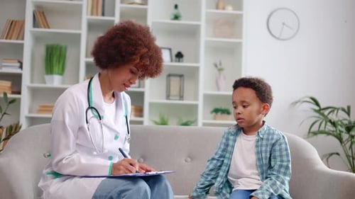 Doctor Taking Notes While Talking to Child