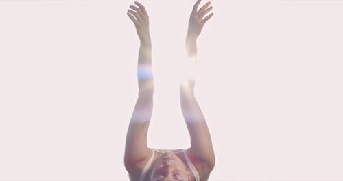 Woman Stretches Arms Upward Toward the Sunlight