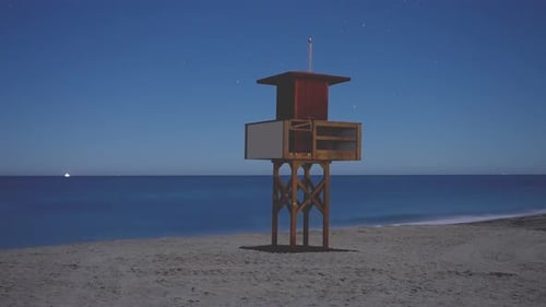 Small lifeguard tower at night, time lapse on the Mediterranean coast