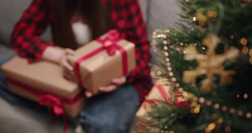 Woman With Christmas Presents on Couch Near Tree