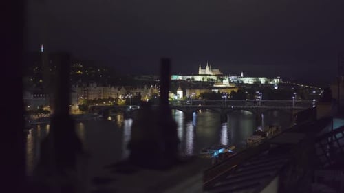 view of Prague castle and Vltava river from a rooftop at night