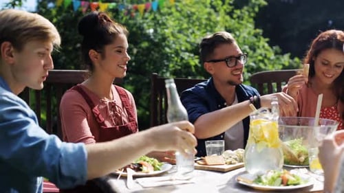 Leisure, Holidays, Eating, People And Food Concept - Happy Friends Having Dinner At Summer Garden...