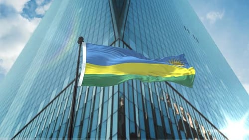 Rwanda Flag Waving in Front of Modern Corporate Building