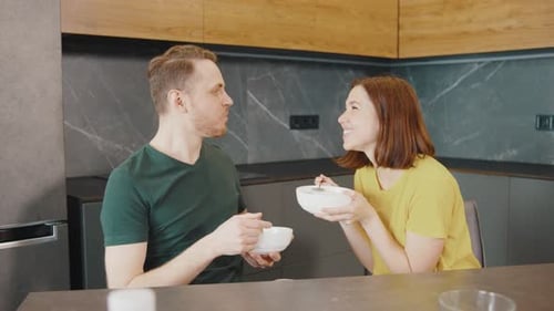 Happy Couple Eats Breakfast in Modern Kitchen