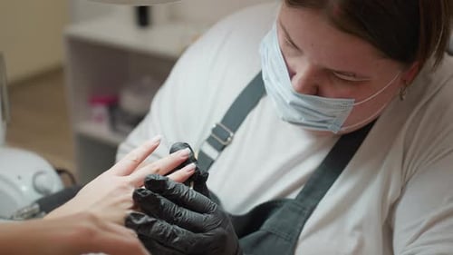 Manicurist Giving Client a Manicure in Beauty Salon