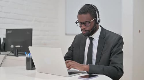 Young Adult Man Typing on Laptop in Office
