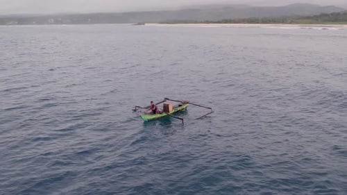 Aerial view of sunrise fishing scene with traditional boat, Indonesia.