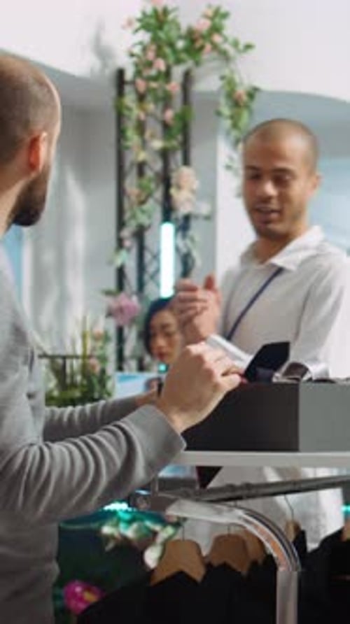 Man Shopping for Ties in Clothing Store