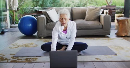 Senior Woman Exercising at Home on Yoga Mat