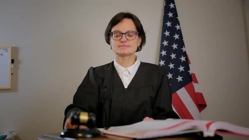 Judge With Gavel Writing in Law Book