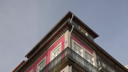 A Building Featuring Traditional Red-tiled Walls, Narrow Wrought-iron Balconies
