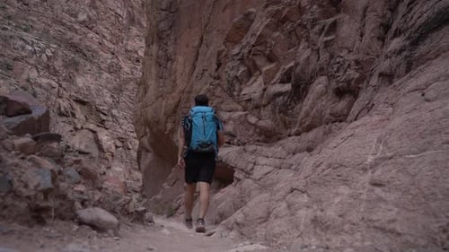 Lonely Male Hiker With Backpack Walking Into Narrow Slot Canyon in Grand Canyon National Park, Brigh