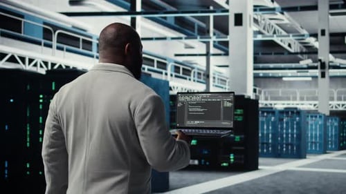 Data Center Computer Scientist Coding on Laptop Doing Software Updates