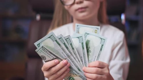Child Holding Pile of One Hundred Dollar Bills