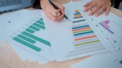 Reviewing Business Report Data with Pen in Office