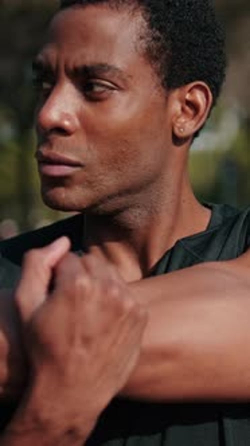 Vertical video, Fit Black Man Stretching in the Park