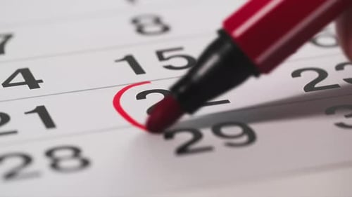Important Event Woman Using Red Felttip Pen Marks Numbers in Calendar Closeup