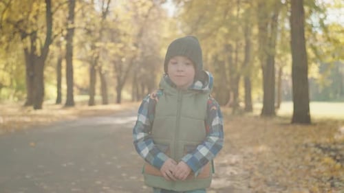 Classroom Bound Young Scholar Hurries Through Autumn Foliage