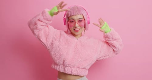 Smiling woman dancing with headphones in studio