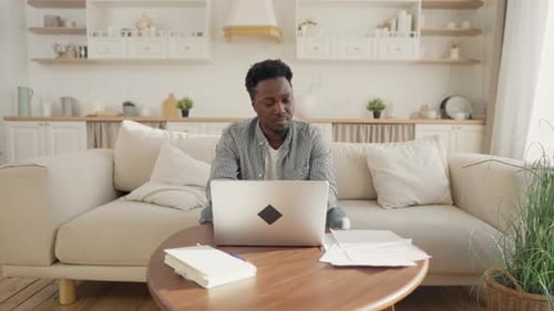 Young Adult Working on Laptop at Home
