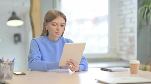 Young Woman Working with Tablet at Table