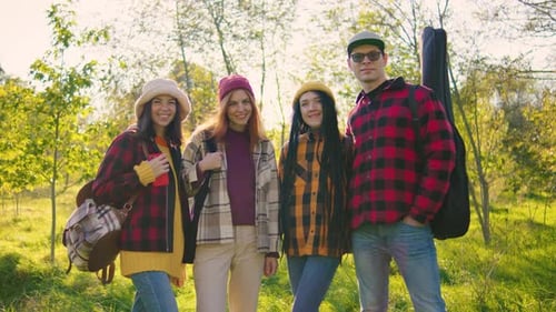 Four Friends Standing Together in Sunny Grassy Woods