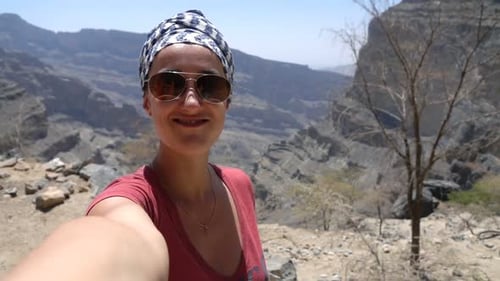 Cheerful young woman records herself trekking through a beautiful Grand Canyon landscape