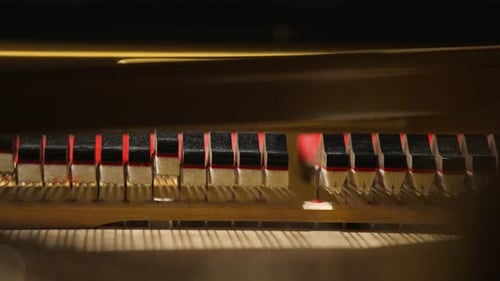 Piano Hammers Striking Strings in Close Up View