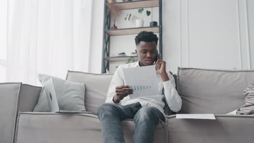Man Working from Home on Sofa with Laptop