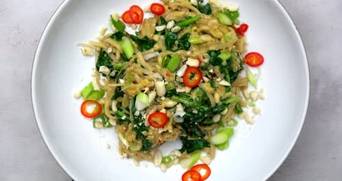 Gluten free noodles. Noodle plate rotating shot in 4k. Vegetarian spicy food. Plant based vegan food