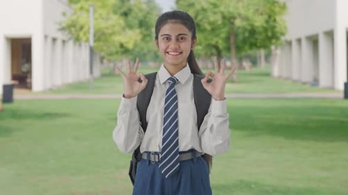 Happy Indian school girl showing okay sign