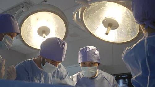 The surgeon team is working in a hospital's operating room.