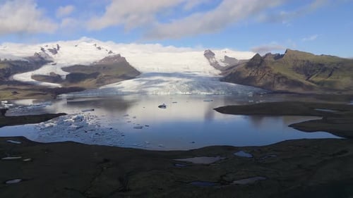 Aerial view of glacier and lake surrounded by mountains, Iceland.