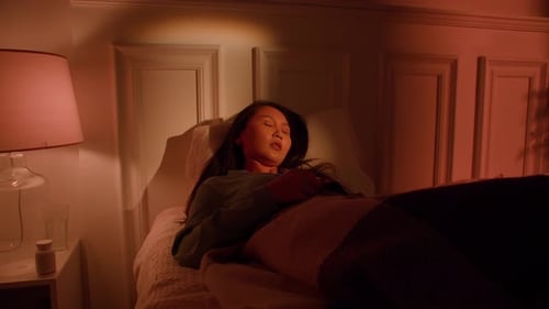 Woman Sits Upright in Bed Beside Partner