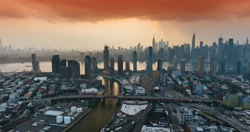 Orange cloudscape covering the sky above New York. Sunset in the metropolis. Skyscrapers at backdrop