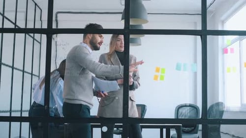 Bunch of stickers on the glass. Professional workers are in the modern office together.