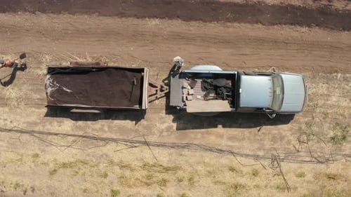 Bird's eye view of Skilled worker men with rake tool leveling fertile soil compost for lawn grass se