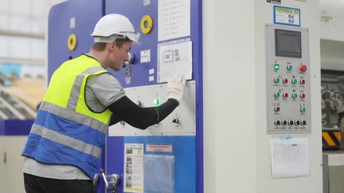 Factory Worker Operating Industrial Machine