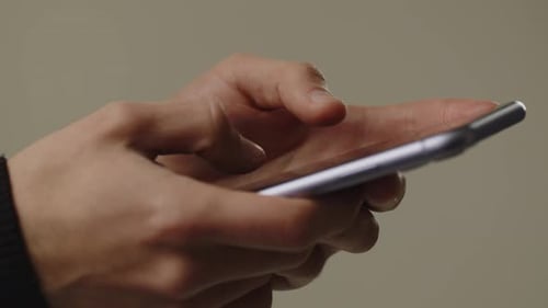 Cropped View of a Man Using Smartphone for Texting A Man Uses a Smartphone to Write Notes Make a