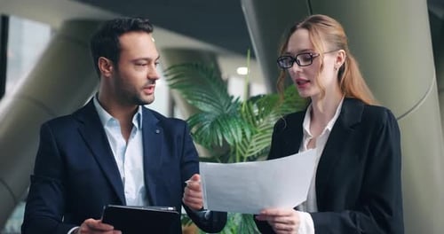 Business Colleagues Discussing Data in Modern Office Setting