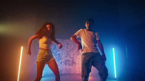Energetic Young Adults Dancing in Lit Urban Studio